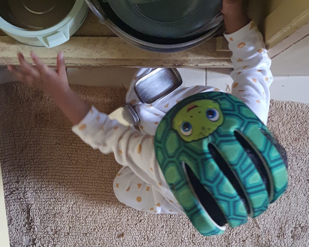 Uma exploring the kitchen cupboards. 