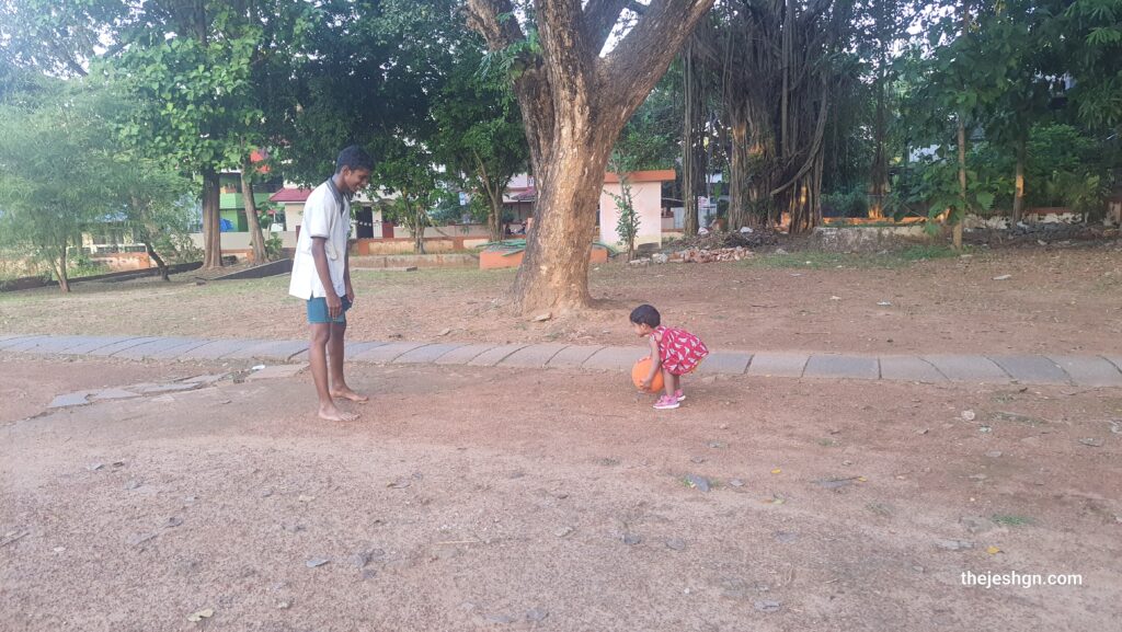 A very young child playing with another child.